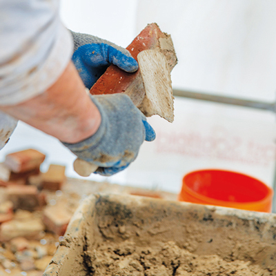  Joe Verzosa, foreman for Tito Masonry, “muds,” or applies cement to the bricks.
