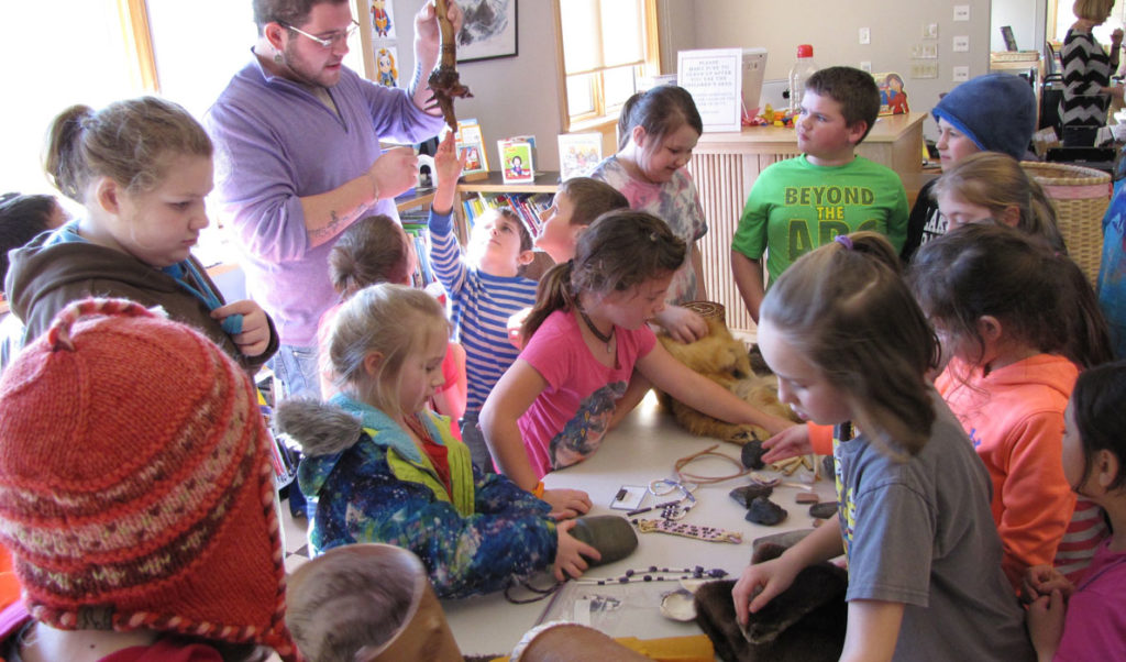 Students from the Swan's Island Elementary School examine some of the artifacts Abbe Museum educator George Neptune brought to his presentation.