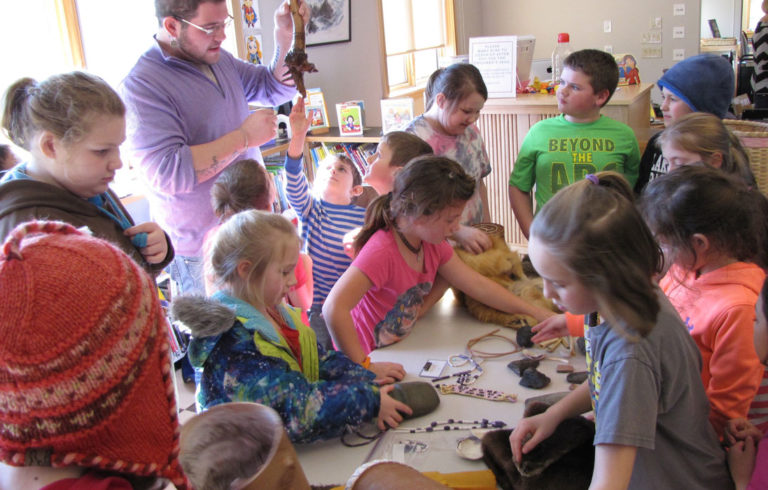 Students from the Swan's Island Elementary School examine some of the artifacts Abbe Museum educator George Neptune brought to his presentation.