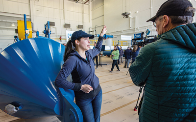 Leaning up against one of the pontoons of the RivGen Power System, ORPC ocean engineer Melozi Scott answers questions about its operation.