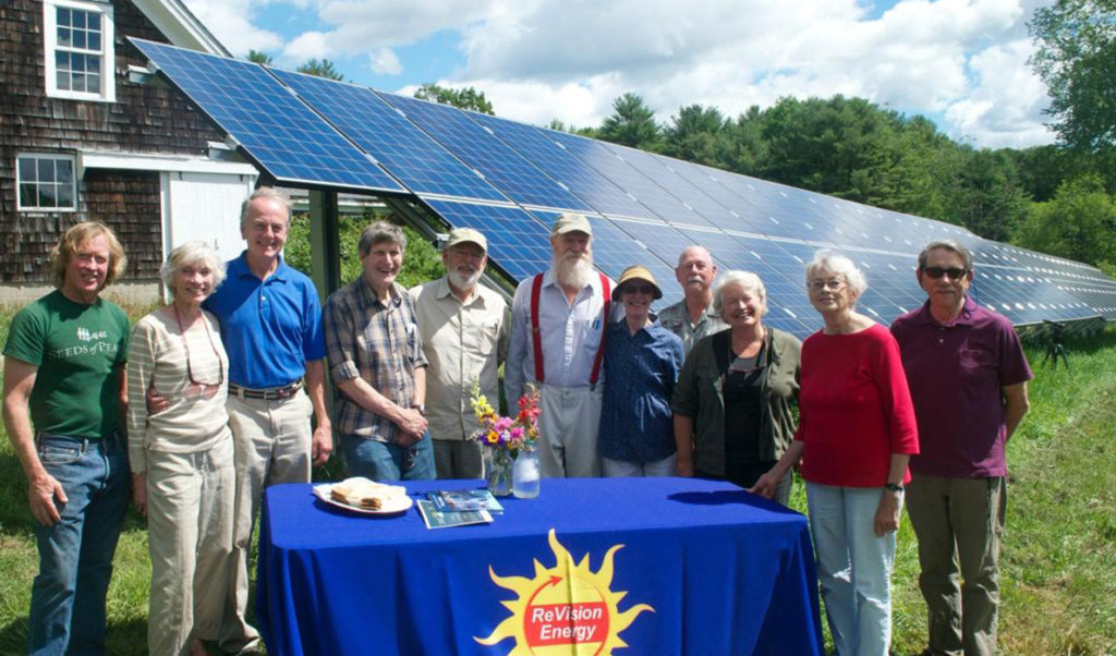 The members of the Edgecomb Community Solar Farm Association with their ground array. Another array is mounted on the barn behind them.