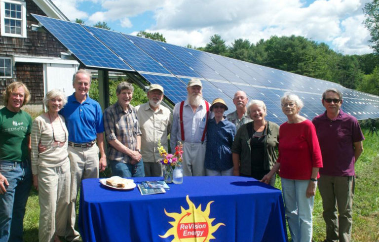 The members of the Edgecomb Community Solar Farm Association with their ground array. Another array is mounted on the barn behind them.