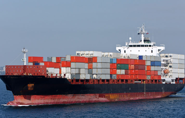 An unidentified ship with containers stacked high on deck.