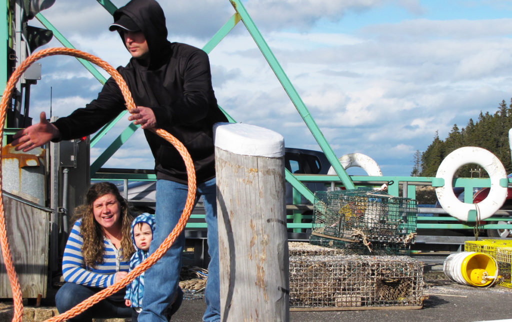 An island family helps a boat land at Frenchboro's ferry landing.