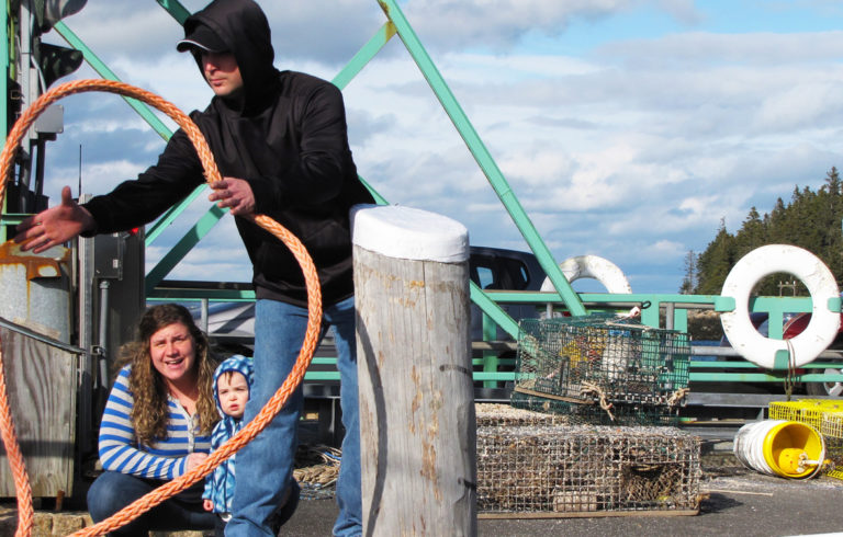 An island family helps a boat land at Frenchboro's ferry landing.