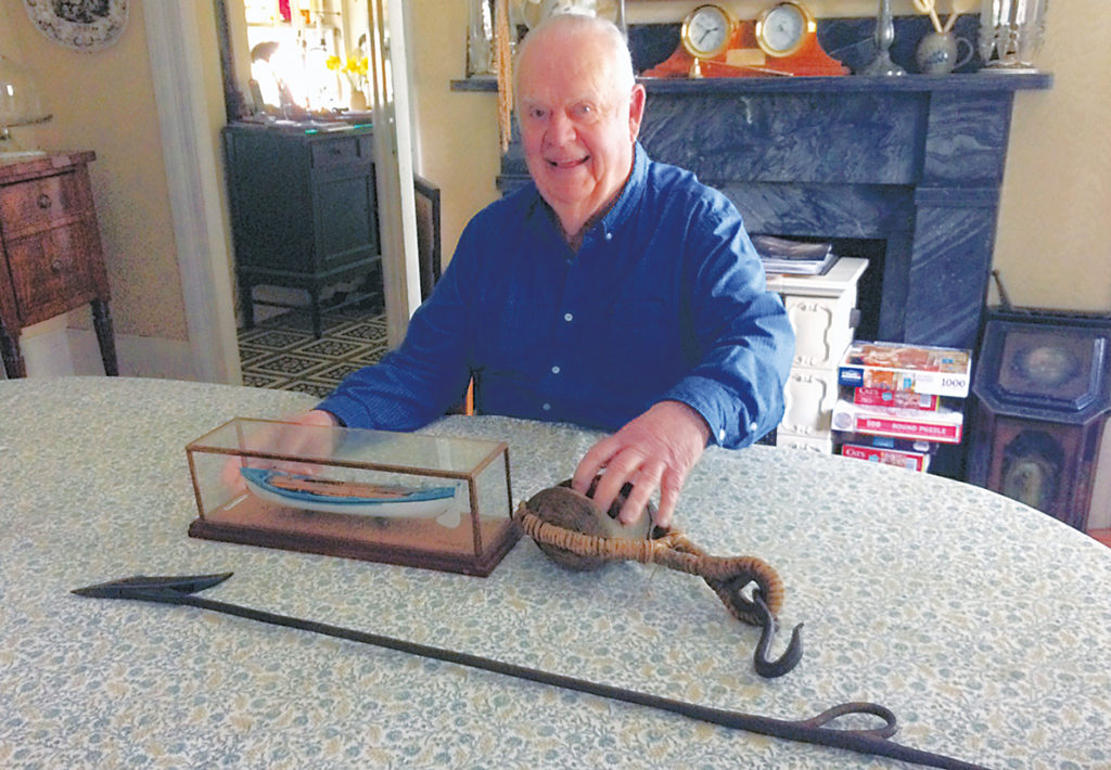 Historian Renny Stackpole poses with some of the implements used in whaling.