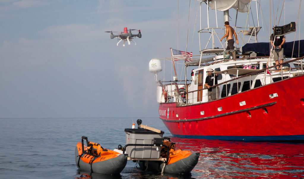 A drone hovers near a simulation of a whale exhaling.