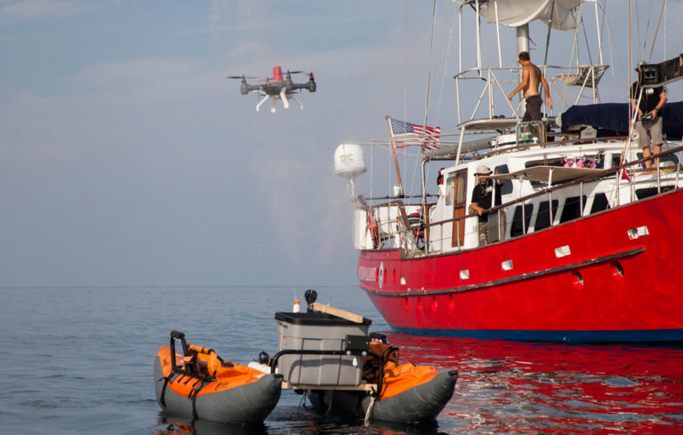 A drone hovers near a simulation of a whale exhaling.