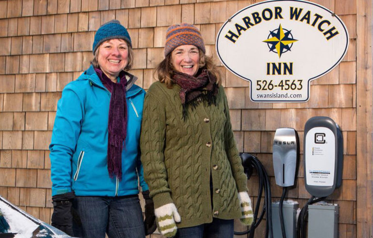 Harbor Watch Inn owner Colleen Hyland (right) looks on as Janice Kenyon of Southwest Harbor uses the inn’s new charging station with her all-electric 2015 Nissan Leaf.