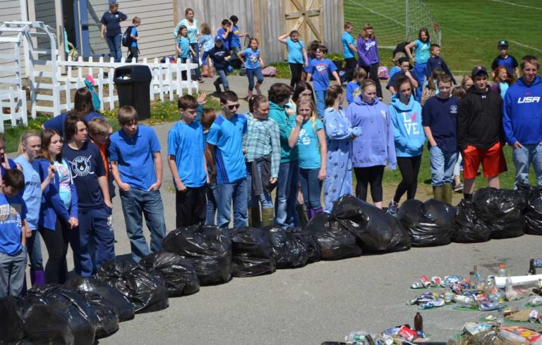 Vinalhaven school students and staff start to congregate outside around the trash collage and spend some time considering all the trash they collected.