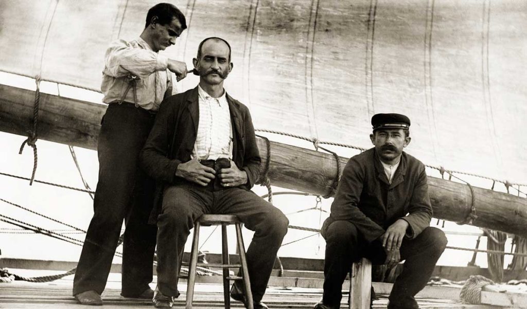 A barber trims hair aboard a vessel out of Thomaston