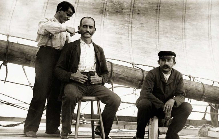 A barber trims hair aboard a vessel out of Thomaston