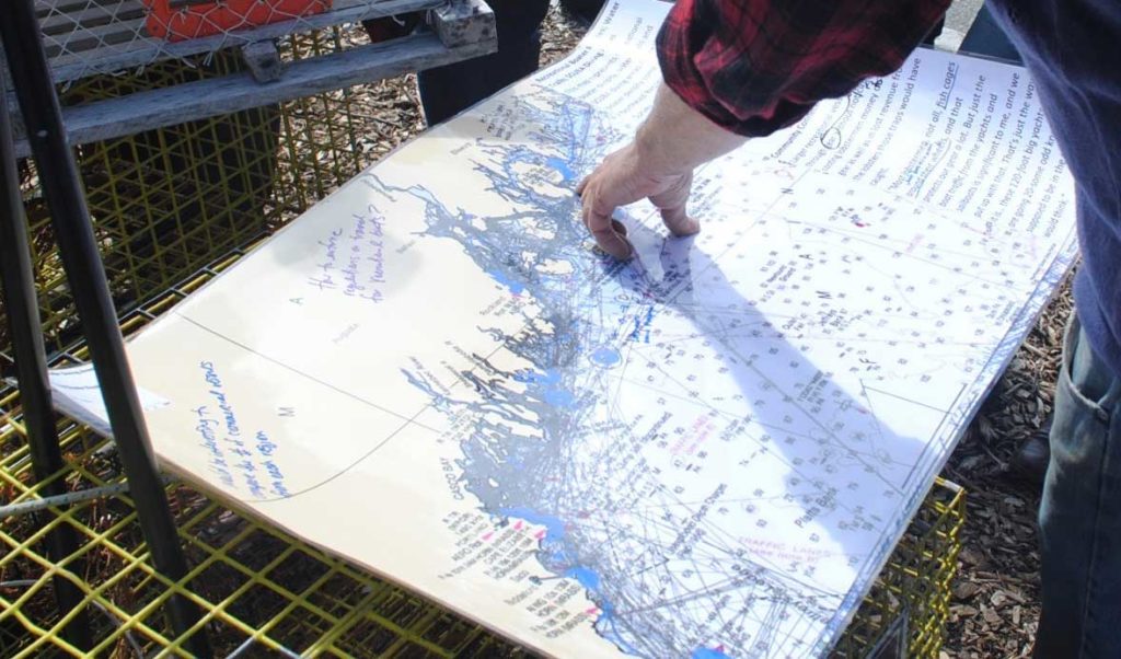 A fisherman points to a part of a map included in the draft ocean plan.