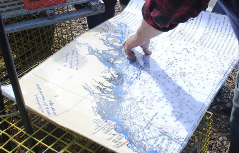 A fisherman points to a part of a map included in the draft ocean plan.