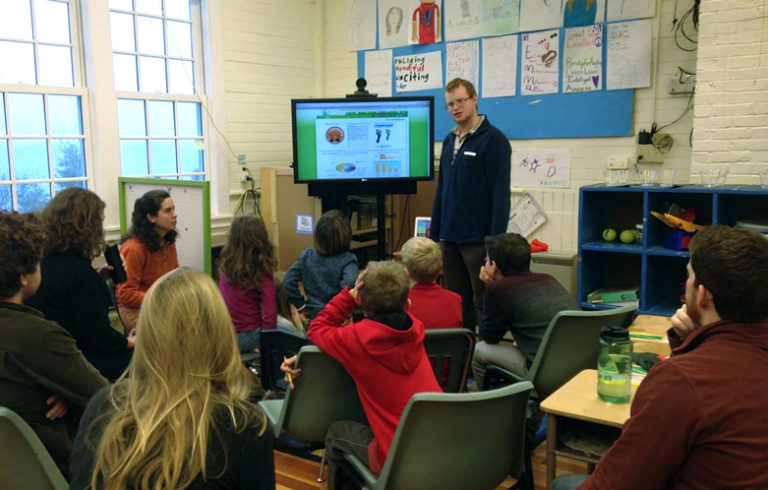 Ben Algeo explains the eMonitor to Monhegan students during Energy Day in January