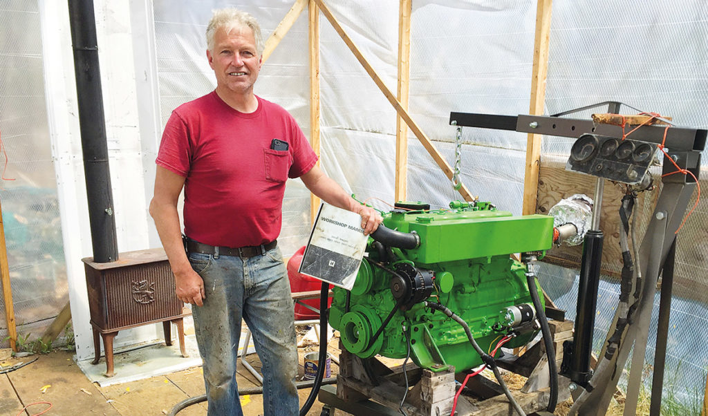 Chris Rich with his rebuilt boat engine.