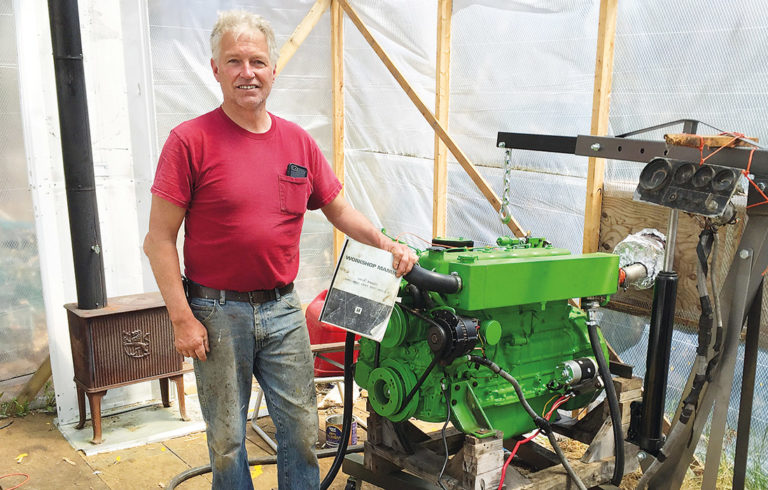 Chris Rich with his rebuilt boat engine.