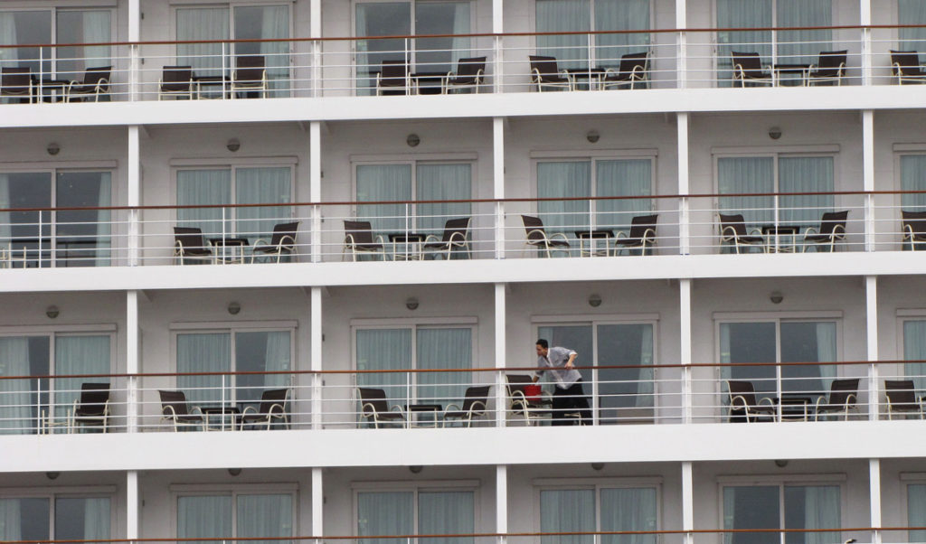 A crew member cleans balconies on a cruise ship docked at Portland’s Ocean Gateway in 2014.