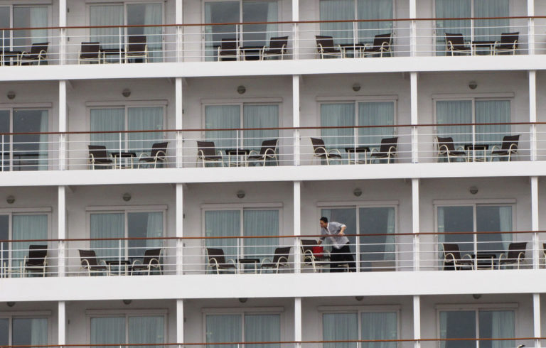 A crew member cleans balconies on a cruise ship docked at Portland’s Ocean Gateway in 2014.