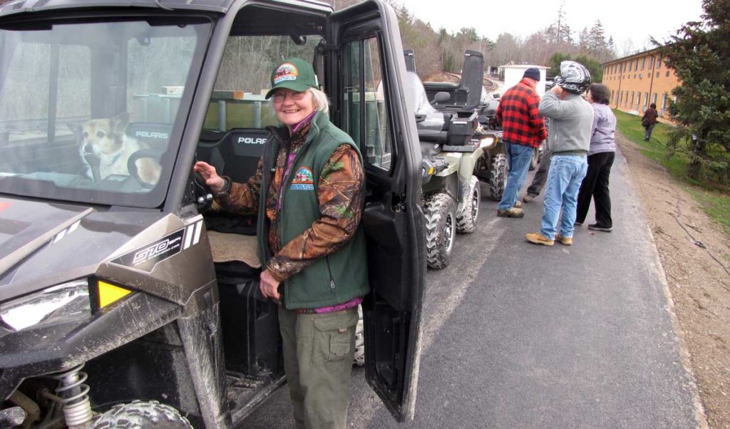 Muggsy Britts and her dog prepare to start her ATV. Britts is a member of the Acadia Area ATV club.