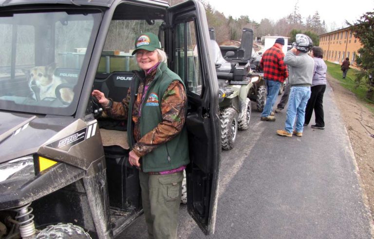 Muggsy Britts and her dog prepare to start her ATV. Britts is a member of the Acadia Area ATV club.