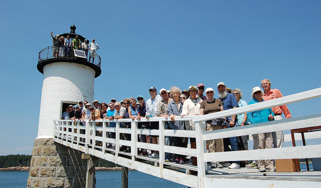 Members of the two island lighthouse committees pose on the walkway at the Isle au Haut light.