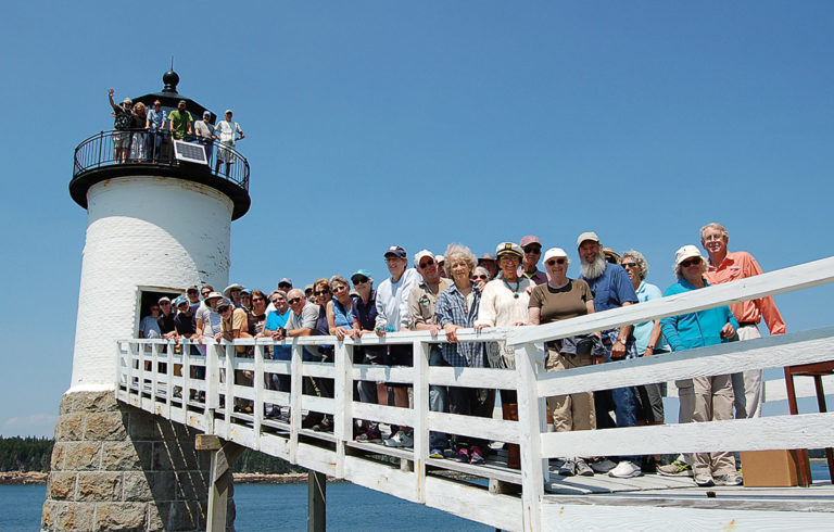 Members of the two island lighthouse committees pose on the walkway at the Isle au Haut light.