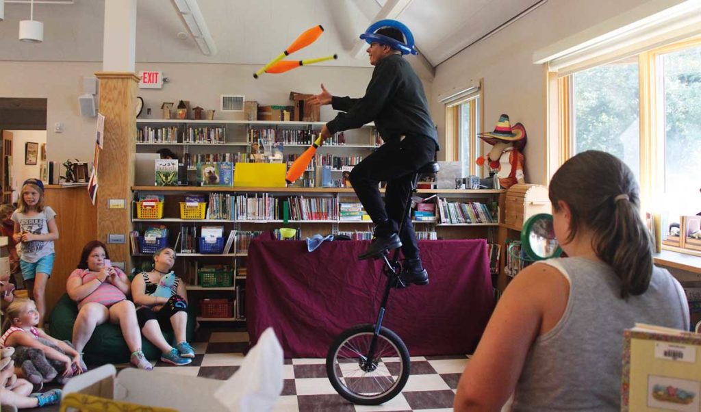 Zach Field wows the crowd as he juggles and rides a unicycle.