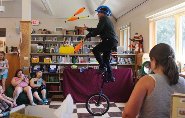 Zach Field wows the crowd as he juggles and rides a unicycle.