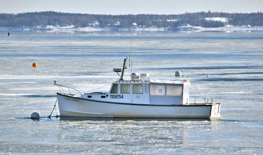 A lobster boat surrounded by ice in Lincolnville Beach.