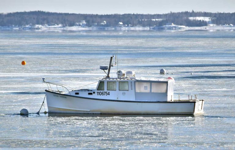 A lobster boat surrounded by ice in Lincolnville Beach.