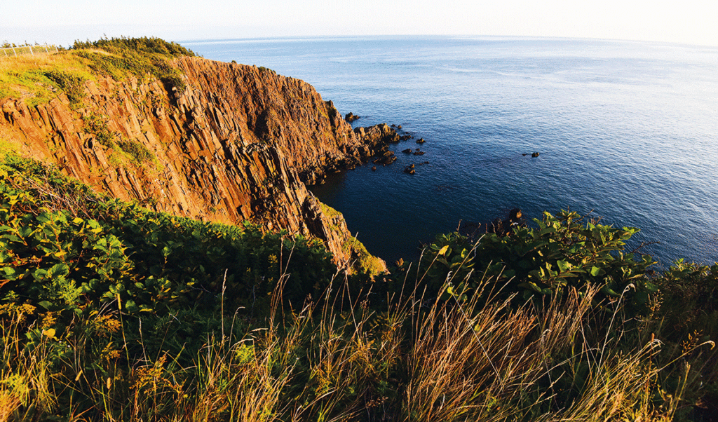 The setting sun strikes the rocks on the island’s sheer