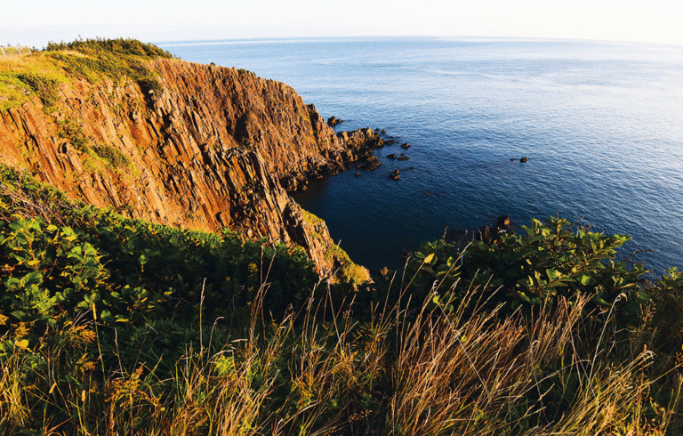 The setting sun strikes the rocks on the island’s sheer