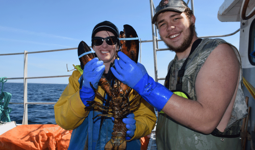 Teacher Kathryn Meyer and student Zack Harvey hold a big lobster.