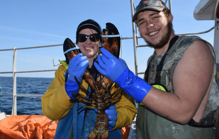 Teacher Kathryn Meyer and student Zack Harvey hold a big lobster.