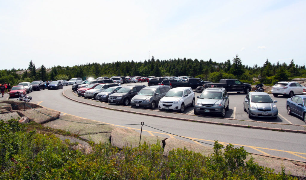 Cars fill the parking spaces at the top of Cadillac Mountain in Acadia National Park.