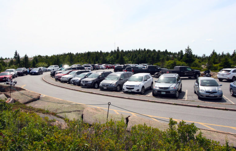 Cars fill the parking spaces at the top of Cadillac Mountain in Acadia National Park.