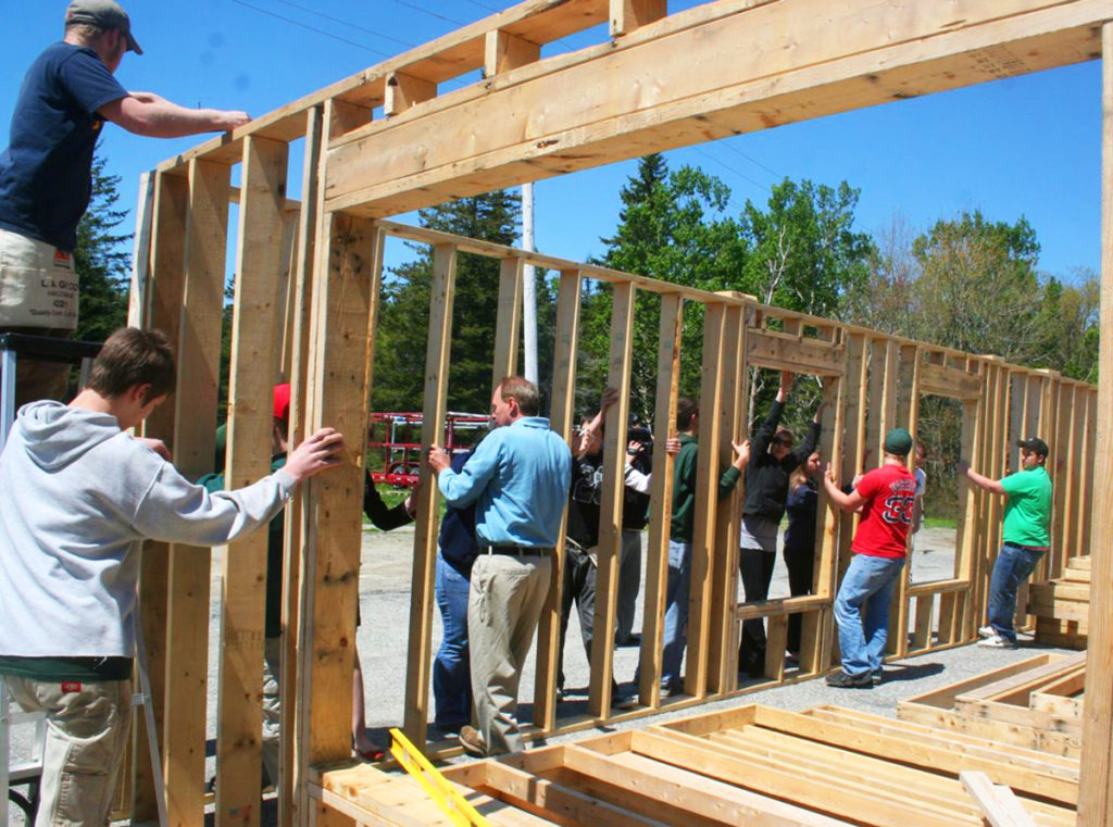 MDI High School students in a previous Habitat for Humanity class do a trial fit of their walls before the units are shipped to the house site.