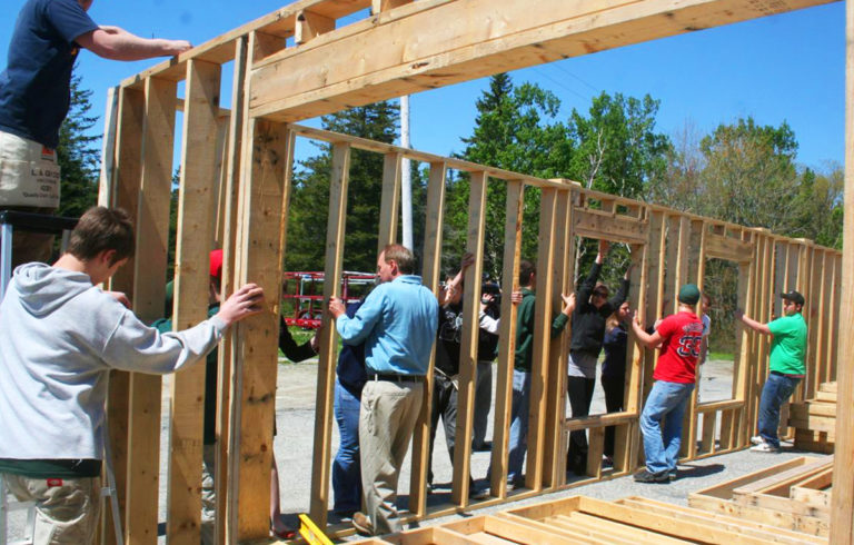 MDI High School students in a previous Habitat for Humanity class do a trial fit of their walls before the units are shipped to the house site.