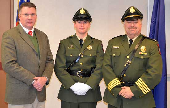 New marine patrol office Daniel Vogel (center) poses with Patrick Keliher