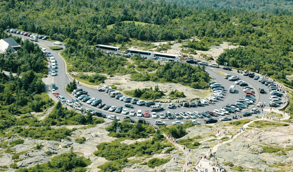 An aerial view of the summit of Cadillac Mountain in Acadia National Park shows cars circling