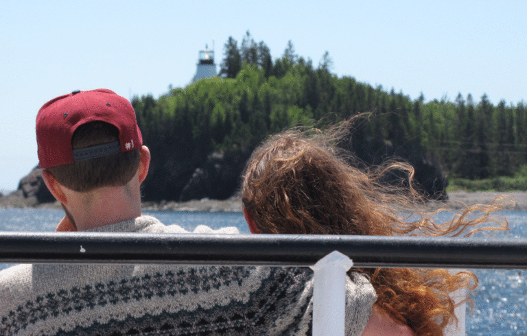 A couple enjoy the Maine State Ferry Service boat ride past Owls Head light on the way to Vinalhaven.