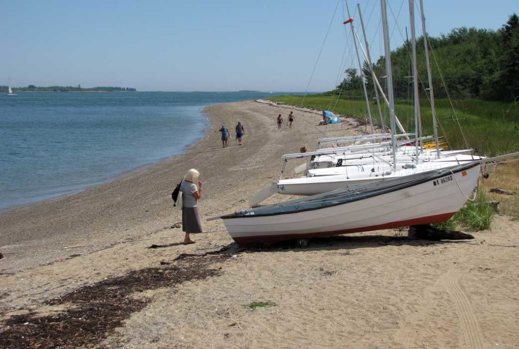 Sailboats and people on Chebeague Island shore.