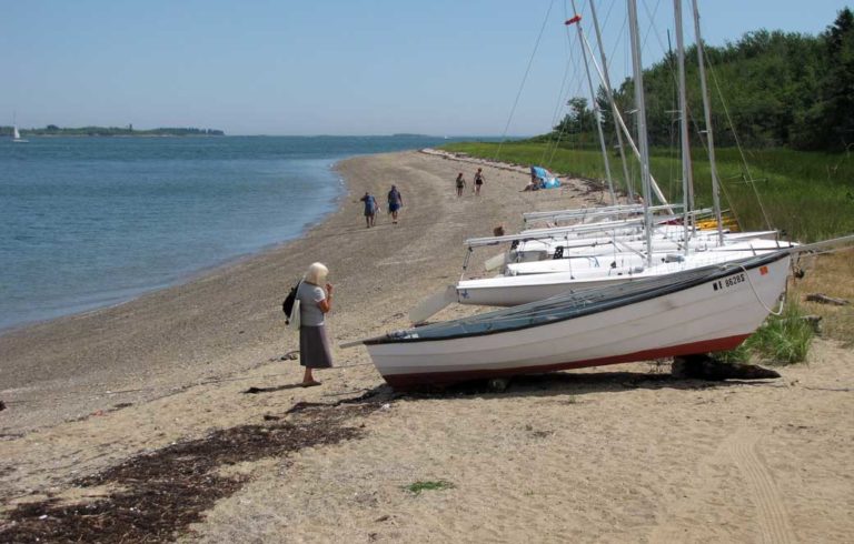 Sailboats and people on Chebeague Island shore.
