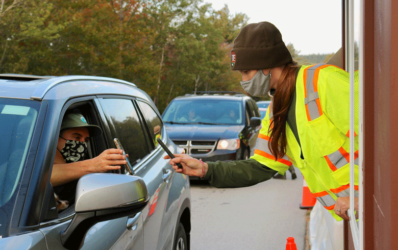 A park ranger uses a mobile device to verify a visitor's reservation at the entrance to the Cadillac Summit Road during an 18-day pilot in October. PHOTO: NATIONAL PARK SERVICE/JOHN KELLY