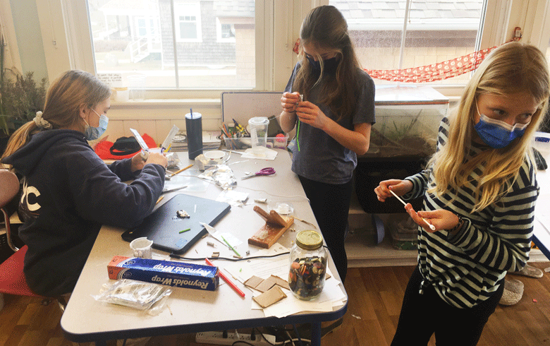 From left are seventh graders Lola Gahan and Hannah Frothingham and fifth grader Lucy Lombard of the Cuttyhunk School. The students built satellite models after the virtual NASA field trip. PHOTO: MICHELLE CARVALHO