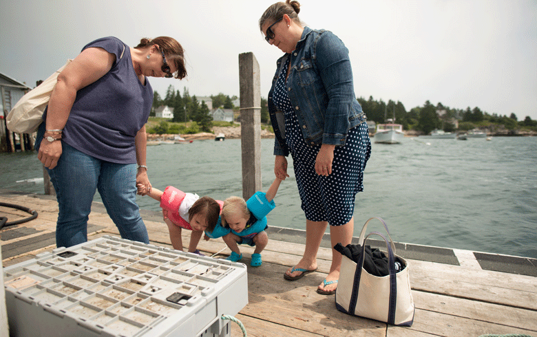 McDonald holds one of her daughters while on a friend's boat in Stonington harbor.