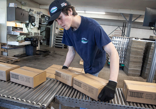 Arthur Ingalls, production associate, prepares boxes for shipping.