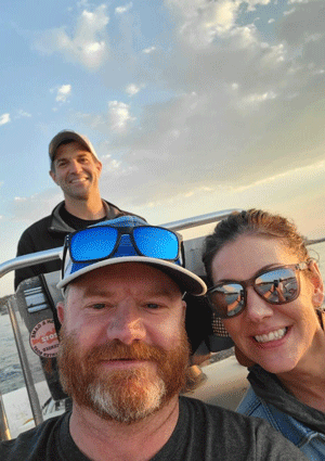 John Herrigel, rear, on a boat with Erik Kleven and Jennifer Lester, owners of the Bleu Duck restaurant in Rochester, Minn.