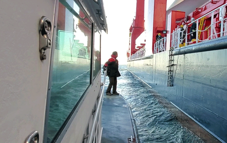 Capt. David Gelinas prepares to jump from the pilot boat onto a moving ship.